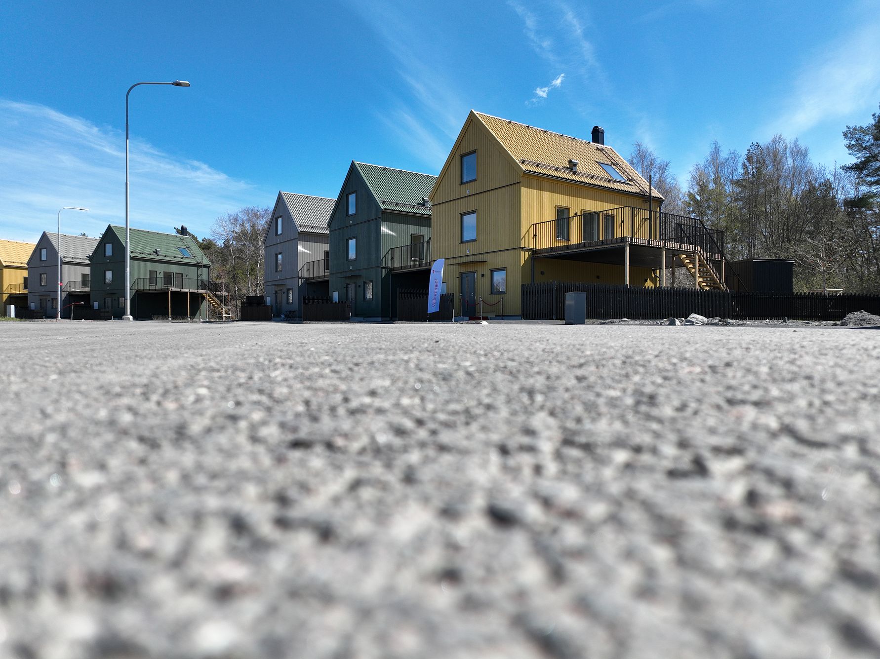 Flera färgglada flerbostadshus vid en gata under en blå himmel