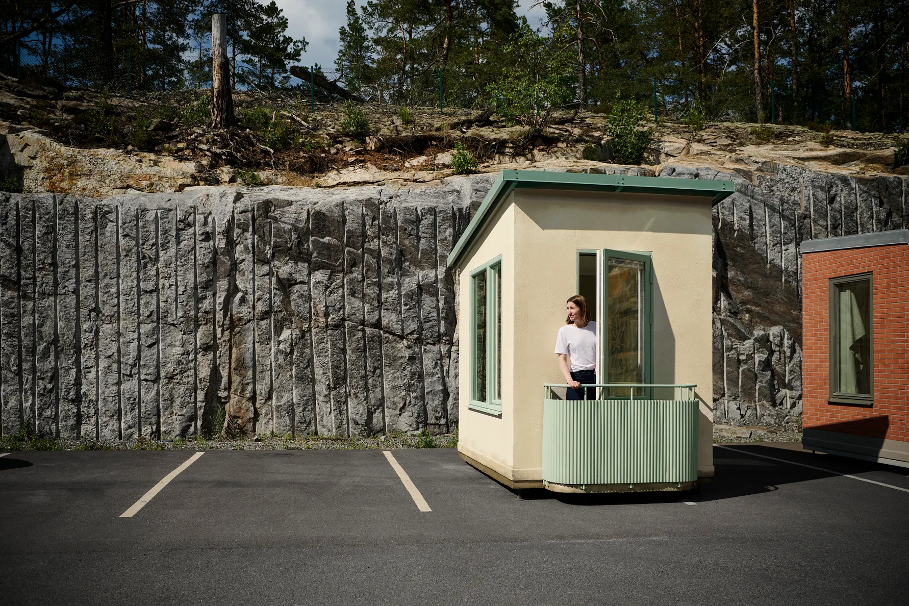 inflyttningsklar lägenhet med kvinna på balkong och bergvägg i bakgrunden