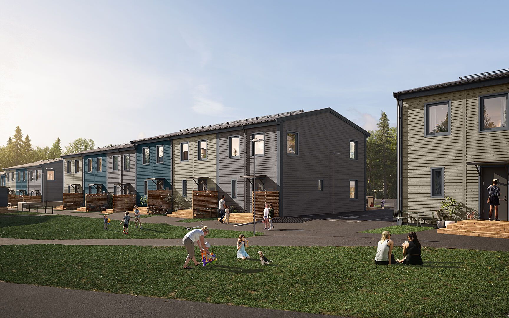 Radhus med modern design i trä på en grönskande gräsmatta med människor som njuter av utomhusaktiviteter