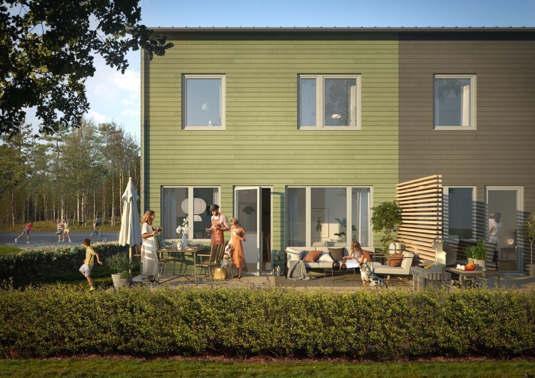 Modernt tvåvåningshus med gröna och grå fasader, stora fönster och en trädgård med människor som umgås på uteplatsen. Bakgrunden visar en grönskande natur och personer som promenerar