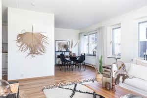 Vardagsrum i vy mot matplats med runt bord och stolar