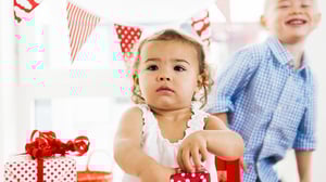 Liten flicka öppnar födelsedagspresent