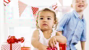 Liten flicka öppnar födelsedagspresent