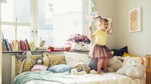 Barn hoppar på säng