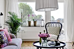 Vardagsrum med soffa och fåtölj ut mot balkong