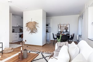 Vardagsrum med soffgrupp mot matplats och kök