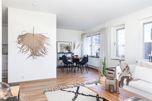 Vardagsrum i vy mot matplats med runt bord och stolar