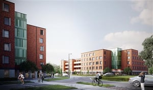 Moderna flerfamiljshus i rött tegel längs en lugn gata, med cyklister och fotgängare i förgrunden