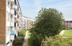 Bostadsområde med flerfamiljshus, grönområden och träd i dagsljus