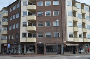 Flerfamiljshus med butikslokaler på bottenvåningen och balkonger på byggnadens framsida