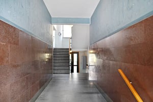 Entré med trappa och korridor, väggar med brädpanel och ljusgrå golv