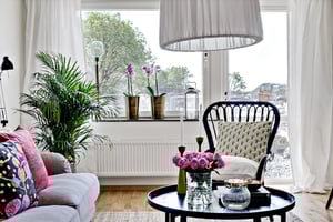 Vardagsrum med soffa och fåtölj ut mot balkong