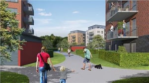 Flerfamiljshus i ett bostadsområde med människor som promenerar och vistas utomhus