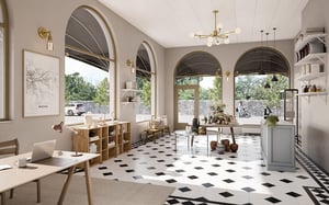 Luftig inredningsbutik med stora välvda fönster, ljusa väggar, svartvit rutmönstrad golv, samt skrivbord och hyllor med dekorativa föremål