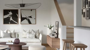 Modernt vardagsrum med vit soffa, träbord och väggkonst i svart och vitt. Taklampa med minimalistisk design hänger ovanför soffan