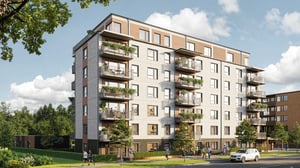 Flerfamiljshus i modern arkitektur med balkonger, grönska och gångstigar i förgrunden under en klar himmel