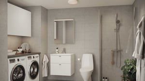 Modernt badrum med grå klinkerväggar, tvättmaskin och torktumlare, vit kommod med spegelskåp, toalettstol, dusch med glasvägg och handdukar på krok