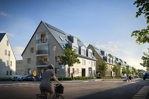 Modern bostadsområde med radhus och lägenheter, cyklist på en gata i förgrunden och människor som promenerar