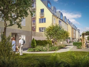 Flerbostadshus med gul fasad, grönskande trädgård och gångväg i förgrunden under klarblå himmel