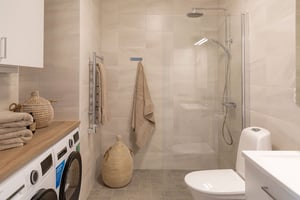 Badrum med duschörna och tvättmaskin och torktumlare i lägenhet på 3 rum och kök