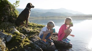 Barn och hund vid vatten