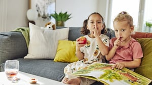 Flickor sitter i soffa och läser bok