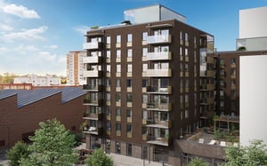 Exteriör av ett modernt flerfamiljshus med bruna fasader, glasbalkonger och gröna omgivningar