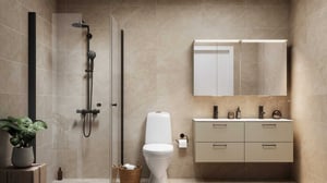 Modernt badrum med toalett, dusch med glasvägg, väggmonterad spegel och skåp, samt beige väggar och golv