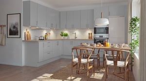 AI genererad bild på kök med grå luckor, högskåp med ugn och mikrovågsugn, kombinerad kyl/frys, diskmaskin. Möblerat med bord och fyra stolar i trä.