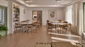 Gemensamhetslokal på trygghetsboende, möblerat med runda bord och stolar i trä.