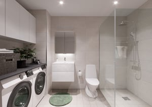 Badrum med dusch, toalett, tvättmaskin, torktumlare, handfat med spegelskåp och grön matta på ljus klinkergolv