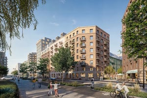 Nybyggda flerfamiljshus i tegel med balkonger, omgivna av träd och människor som promenerar och cyklar på en solig dag