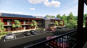 Bostadshus med balkonger, parkeringsplatser och gröna träd