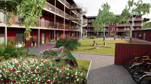 Bostadsgård med röda flerbostadshus, grönskande innergård, cyklar och personer som sitter på gräsmattan
