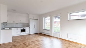 Inflyttningsklar lägenhet med öppen planlösning, vitt kök och trägolv