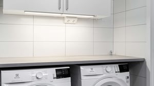 Tomt rum med kaklad vägg, bänkskiva och vitvaror under