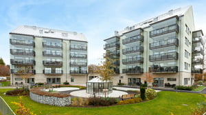 Nyproducerade flerbostadshus med balkonger och gemensam innergård