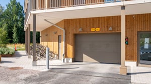 Fasad med garageport och cykelställ vid ett bostadshus
