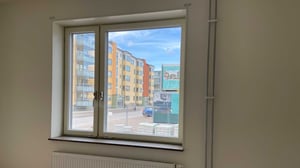 Inflyttningsklar lägenhet med fönster mot flerbostadshus och gata