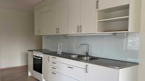 Inflyttningsklar lägenhet med kök i vitt och grå bänkskiva