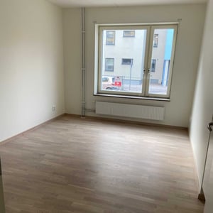 Inflyttningsklar lägenhet med tomt rum och fönster mot innergård