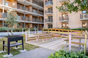 Innergård med grill, picknickbord och balkonger i ett flerbostadshus