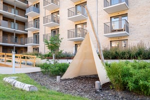 Innergård med modern bostadsbyggnad, balkonger och grönska