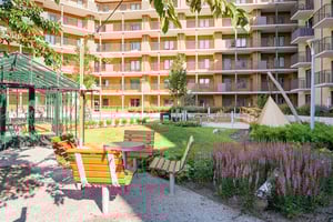 Innergård med sittplatser, växter och flerbostadshus med balkonger