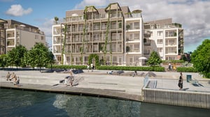 Lägenheter vid vattnet med grönskande balkonger och människor på kajen