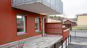 Röd fasad, balkong och uteplats