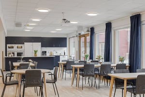 Tomt rum i gemensamhetslokal med kök, matbord och stolar
