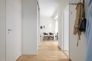Inflyttningsklar lägenhet med ljus hall, trägolv och öppen vy mot matplats