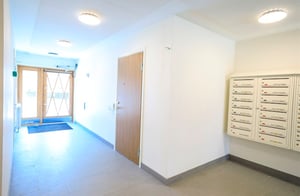 Trapphus med postboxar och ljusa väggar