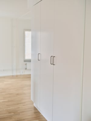 Inflyttningsklart rum med vita garderober och ljusa trägolv, inflyttningsklart
